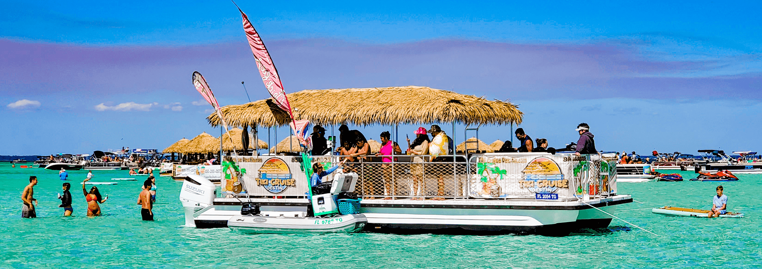 Tiki pontoon boat with passengers in turquoise Destin waters