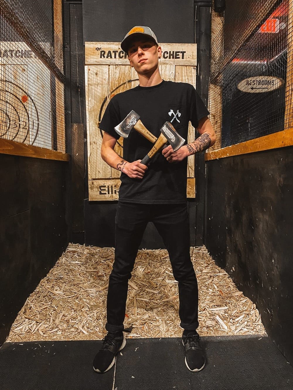 Instructor holding axes in indoor Ellicottville axe lane