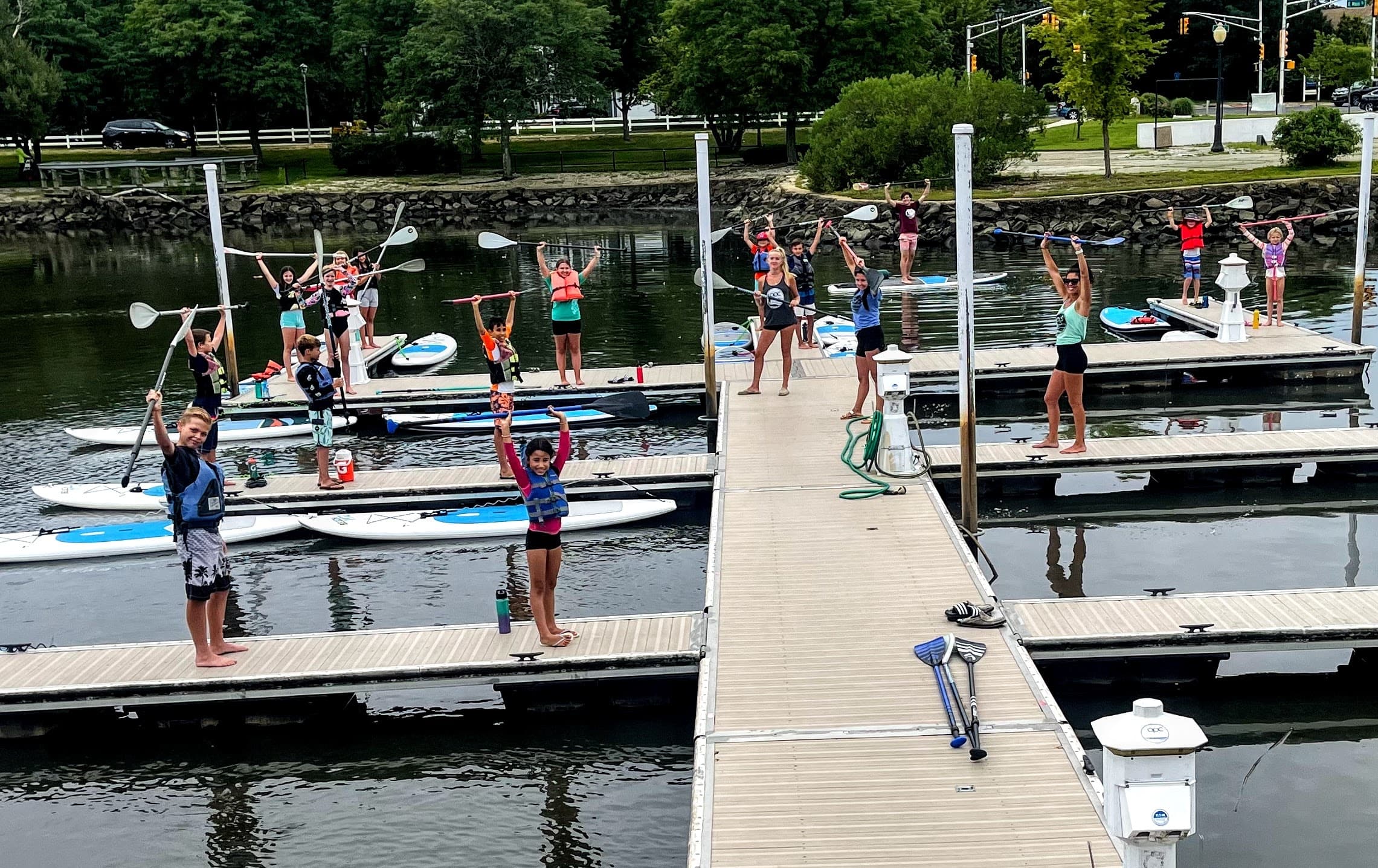 Busy paddleboard dock scene with instructors and participants