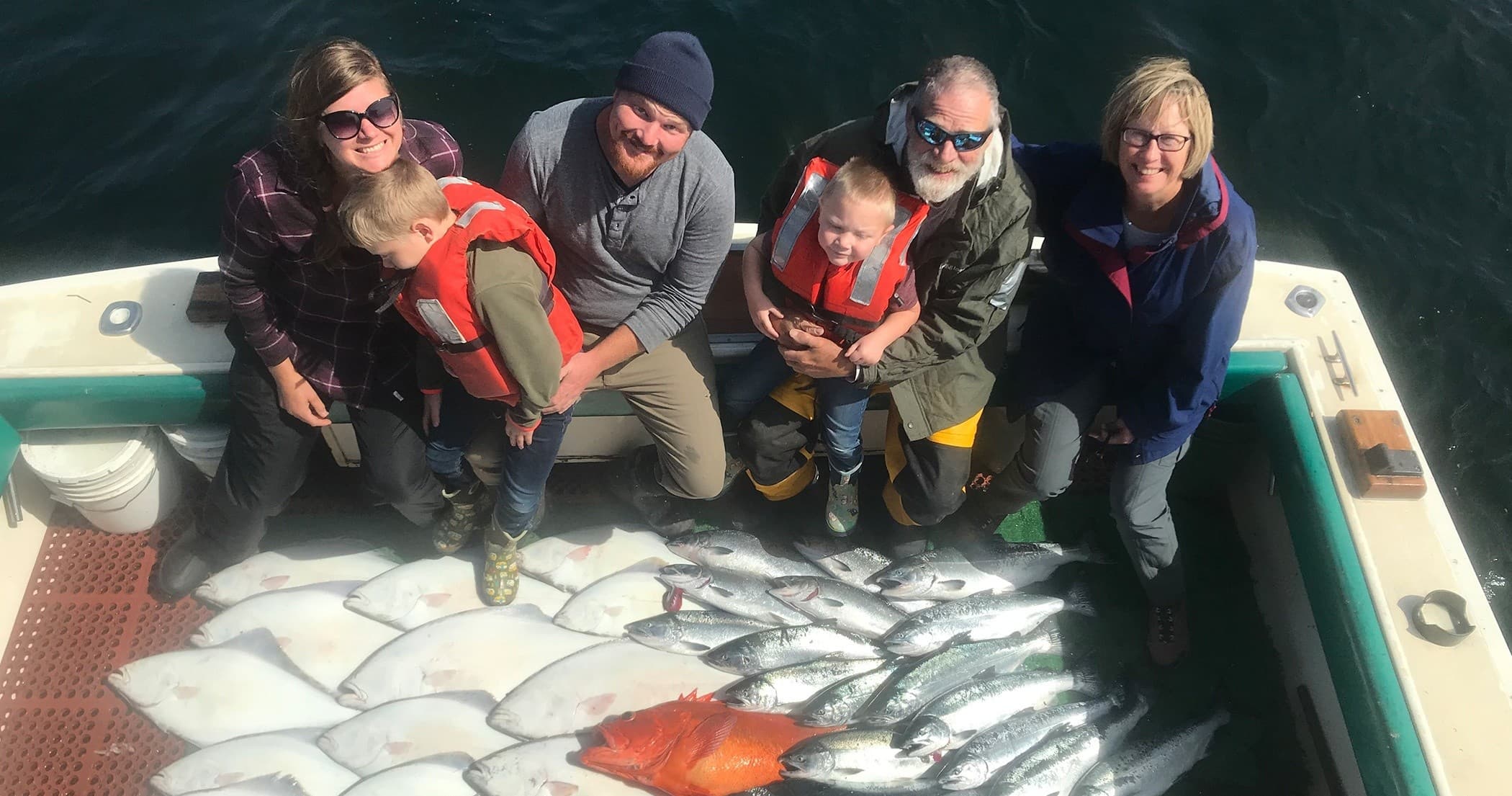 Family fishing trip on Alaskan waters with fresh-caught rockfish