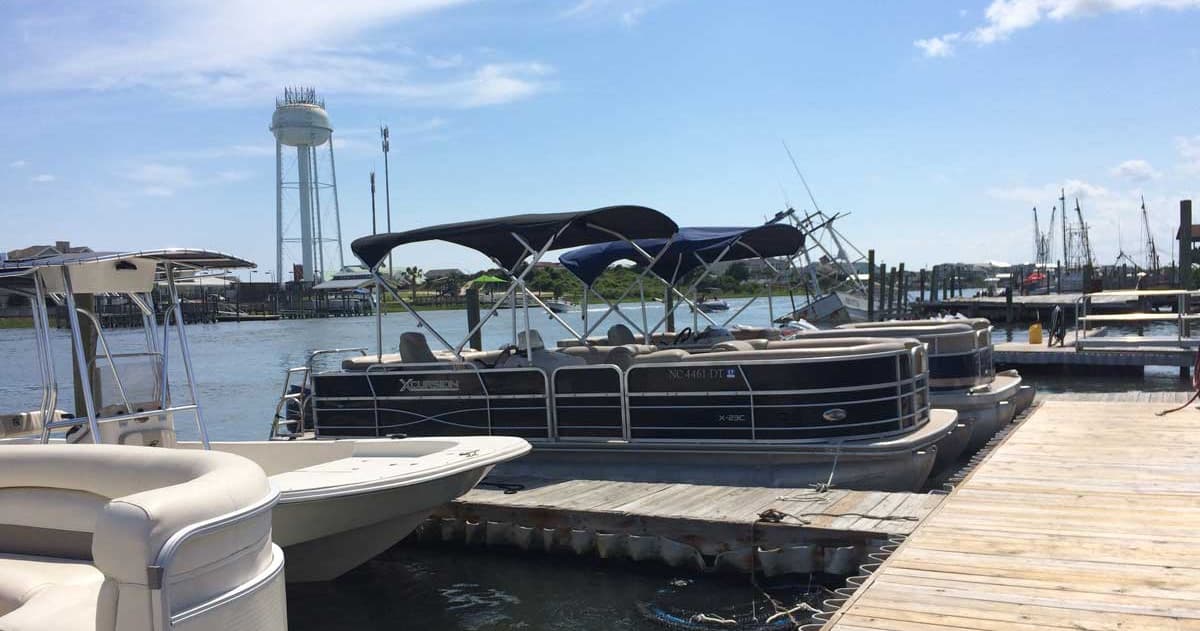 Pontoon boats docked at a coastal marina, scenic harbor cruising