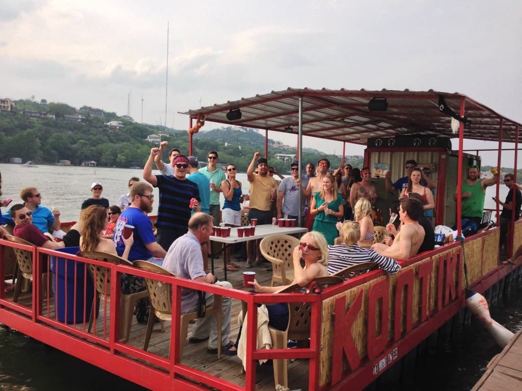 Outdoor deck party on pontoon boat cruising hill country lake
