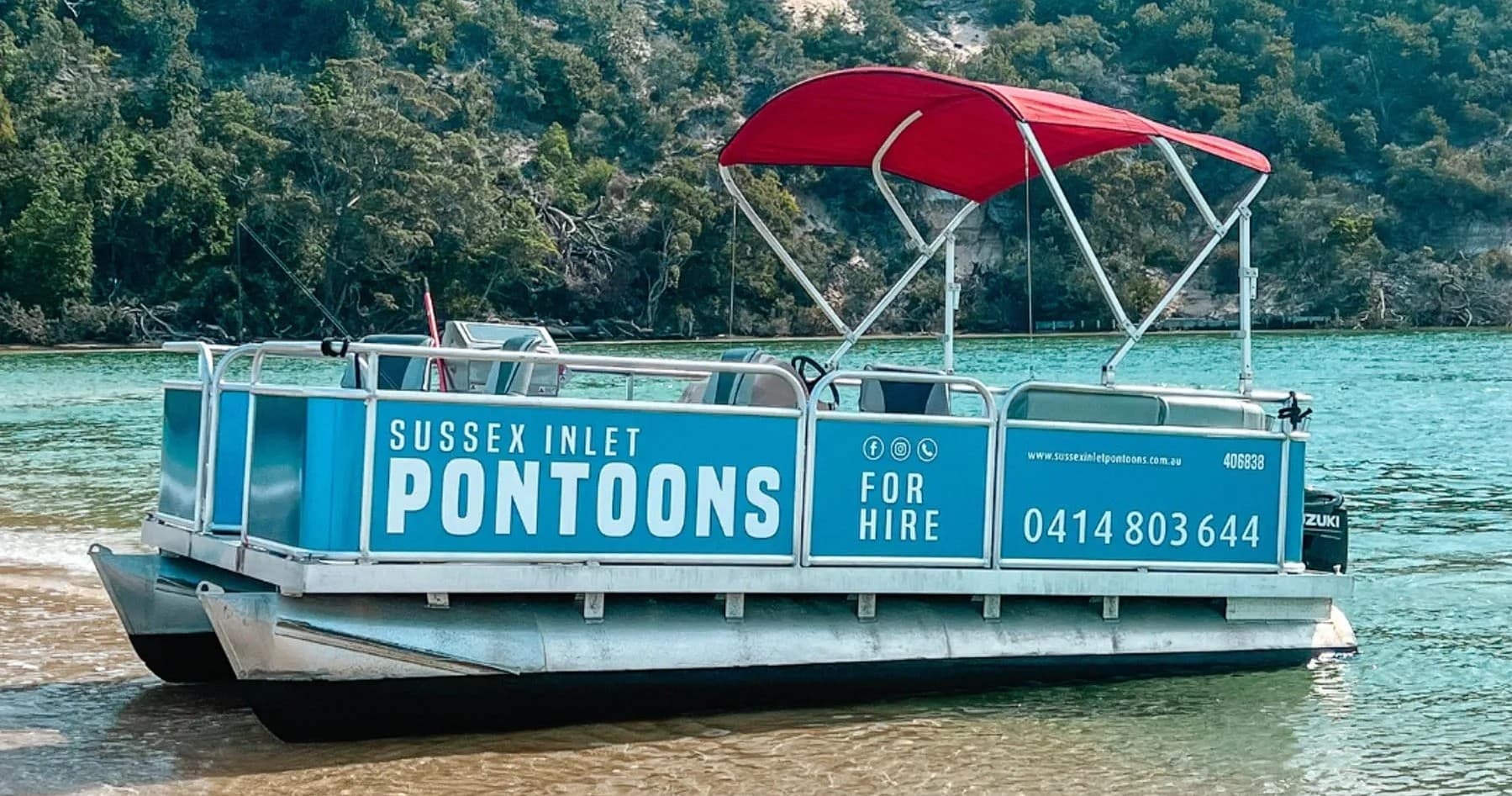 Small hire pontoon anchored in calm inlet waters with canopy