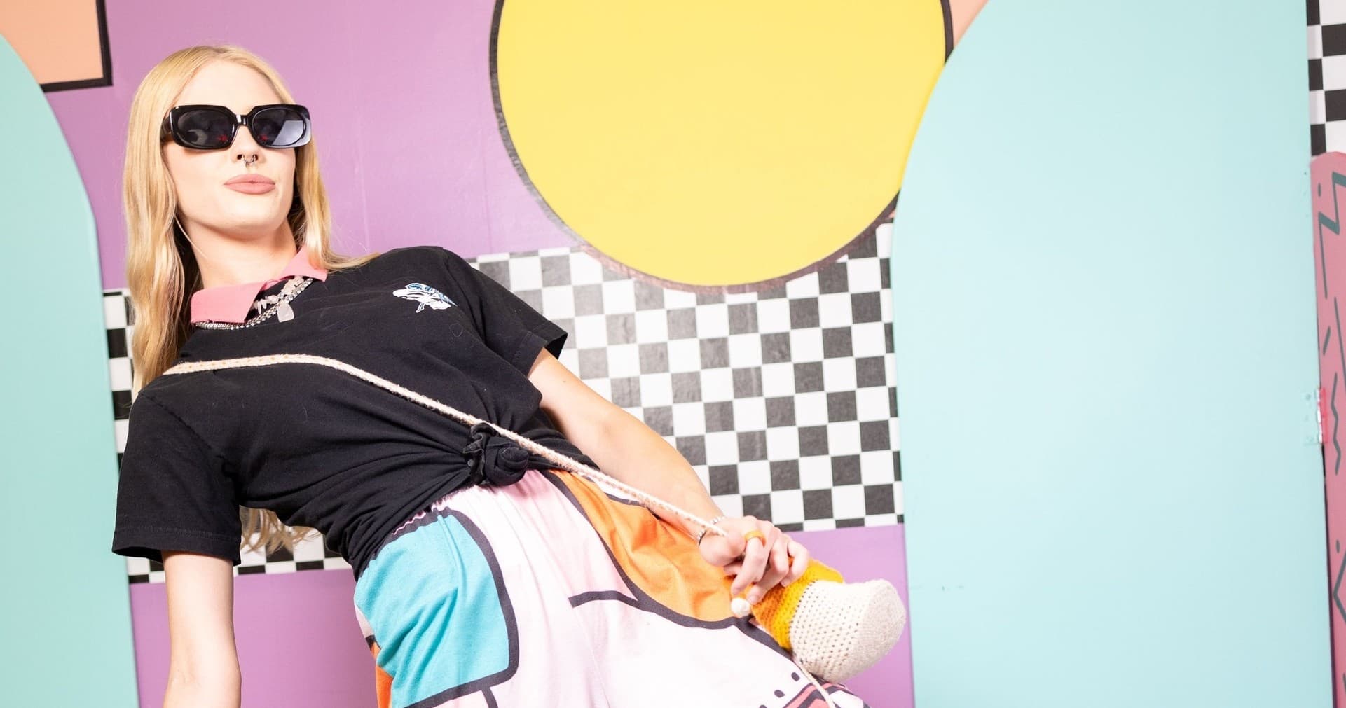 Model posing in colorful indoor selfie room with geometric props
