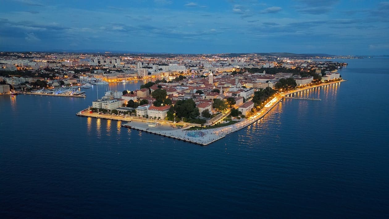 Aerial dusk view of coastal town peninsula and shoreline