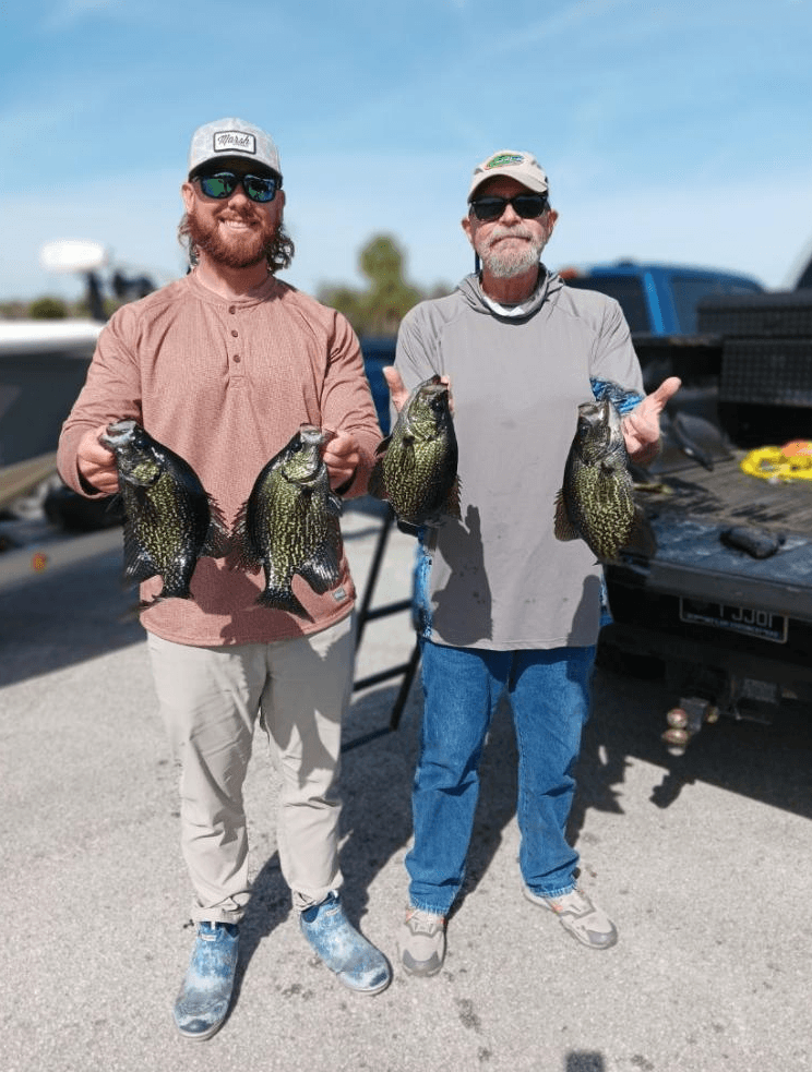 Anglers displaying crappie catches at dock after charter trip