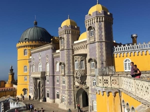 Visitors exploring Pena Palace exterior, Sintra, Portugal