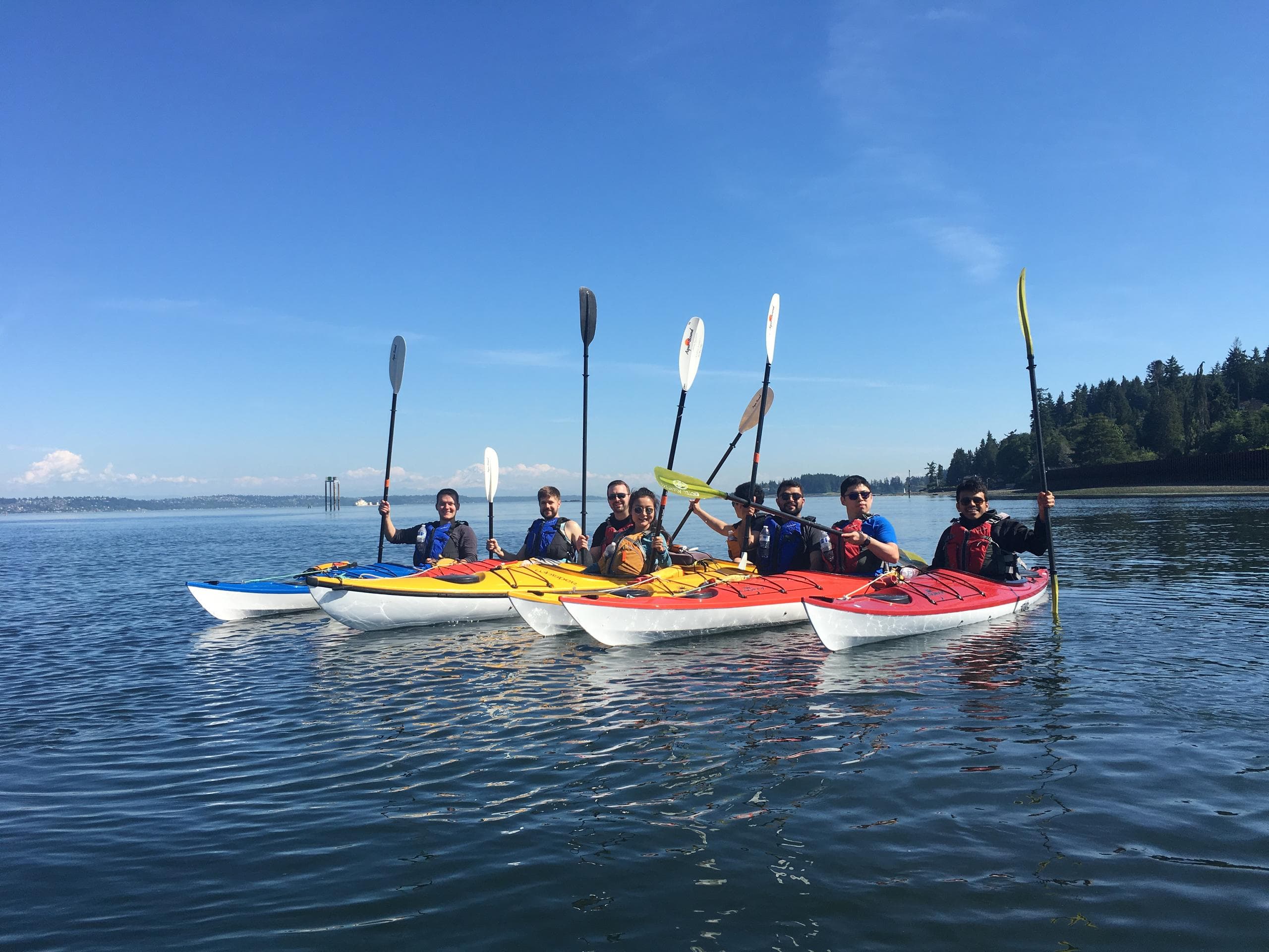 Group of kayakers paddling together across calm coastal waters