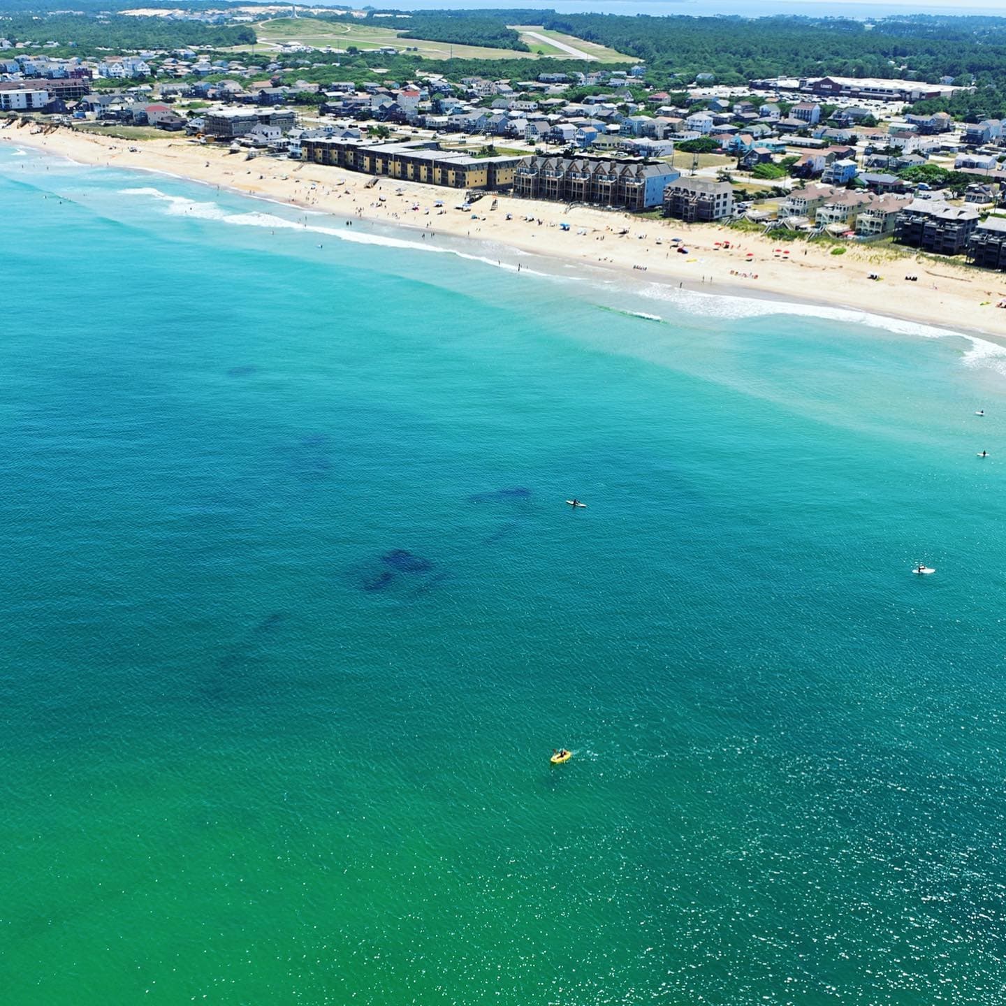 Aerial view of coastline and swimmers at sandy Atlantic beach