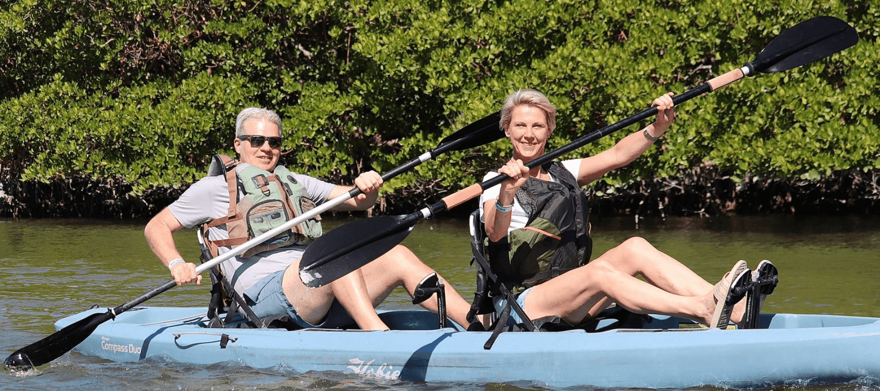 Two paddlers kayaking together on calm estuary waters