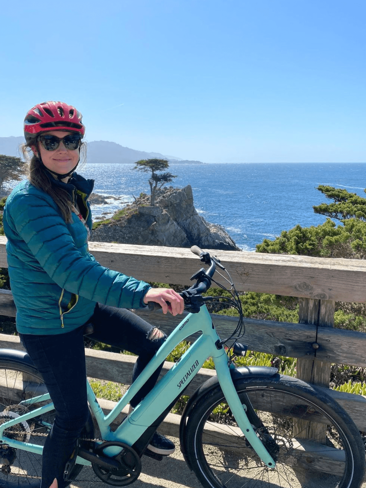 Woman e-biking at coastal overlook with rocky ocean views