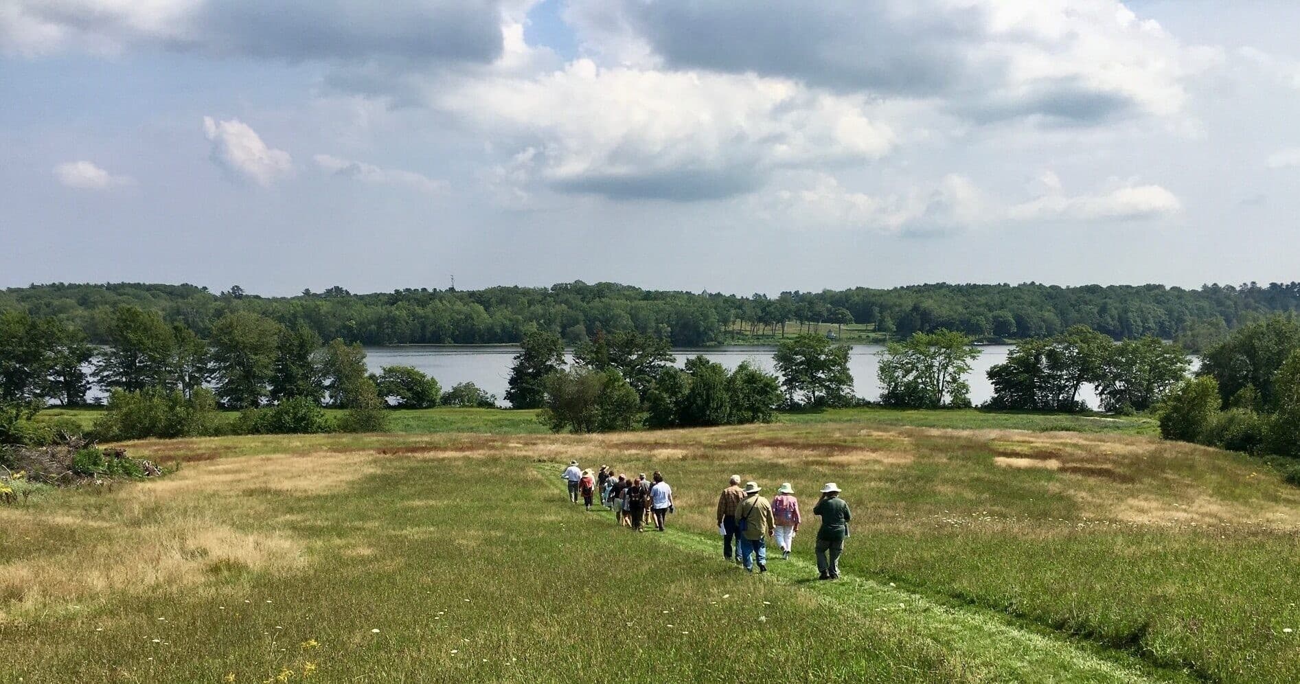 Guided group meadow hike overlooking river and wetlands in Maine