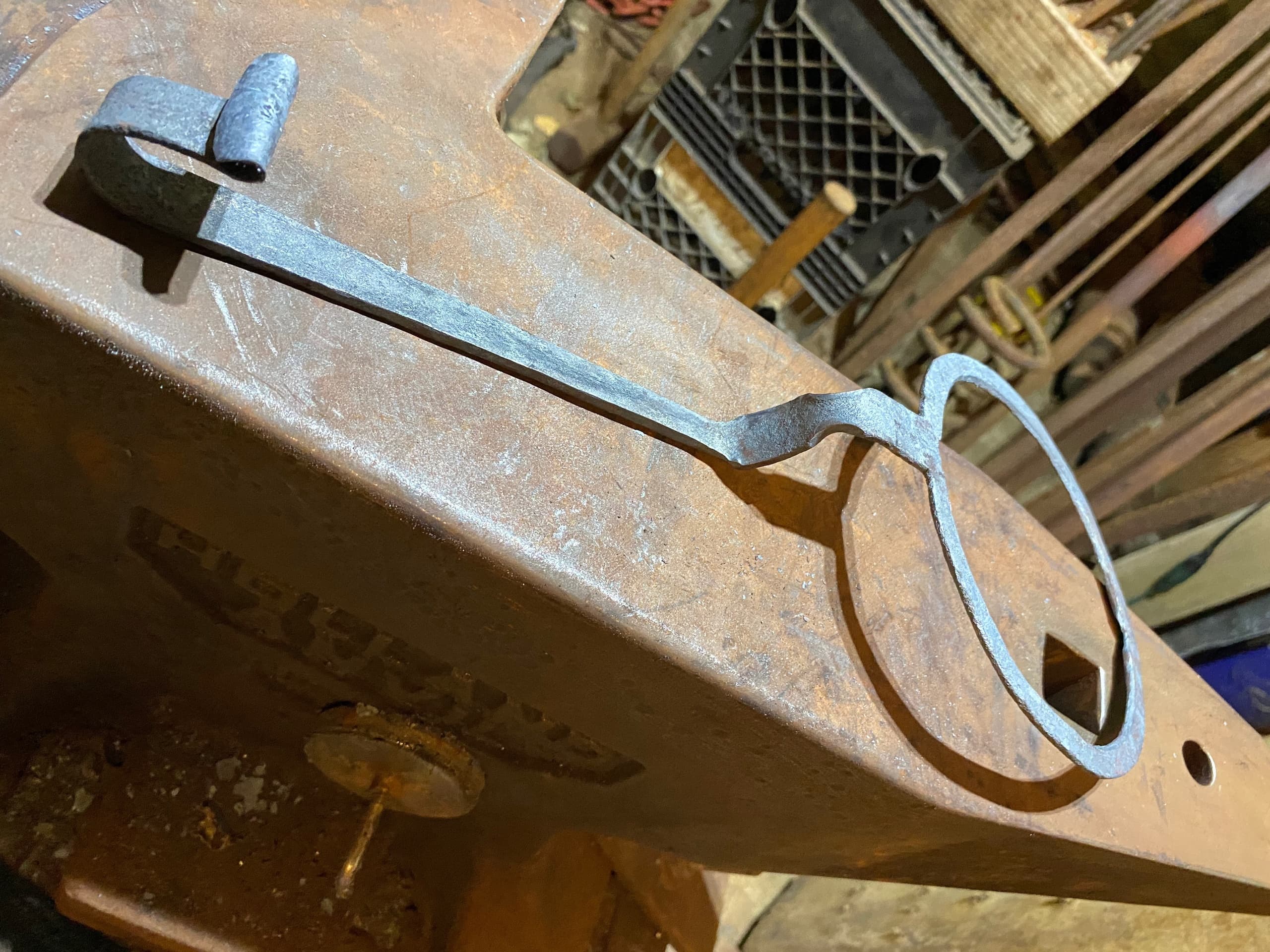 Blacksmith tongs and ring on anvil in forge workshop