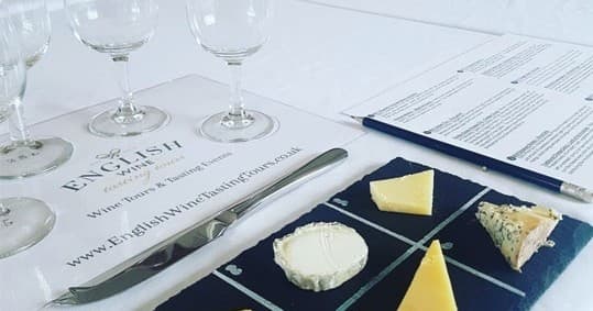 Cheese and wine tasting setup indoors during English wine tour