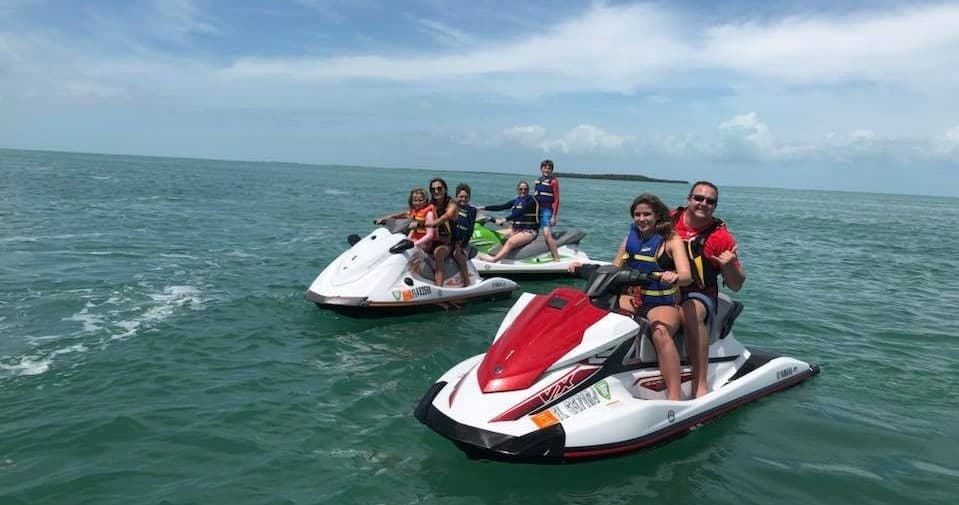 People riding jet skis on open ocean, group watersport adventure