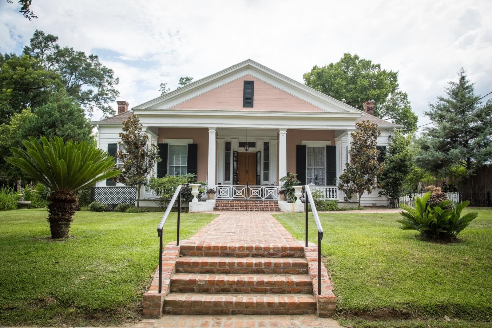 Southern cottage porch and brick walkway in Natchez estate