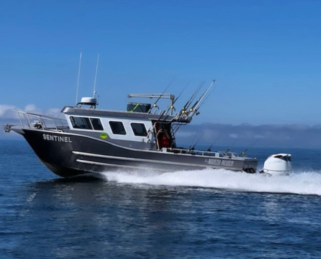 High-speed fishing charter boat powering through Alaskan waters