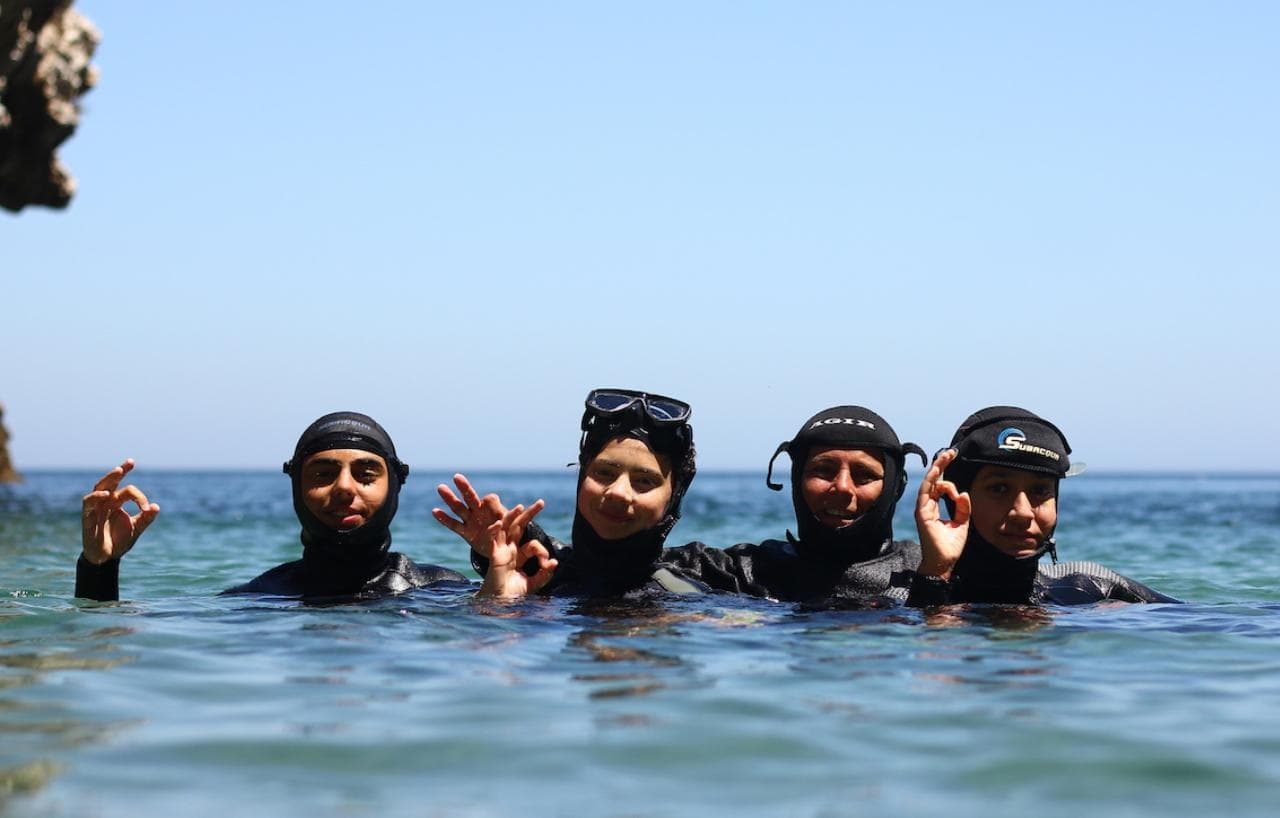 Group snorkeling near rocky shore on coastal reef trip