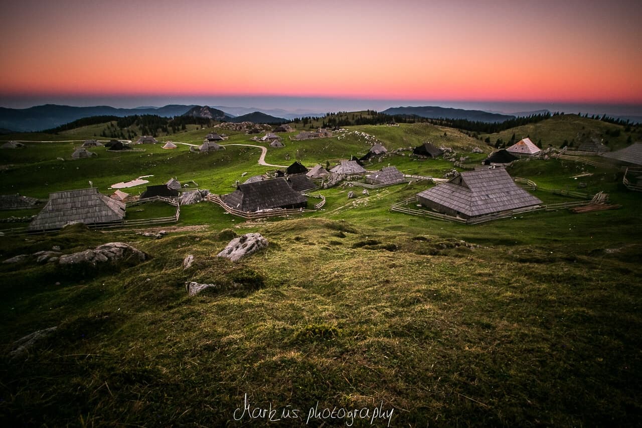 Sunset over rural highland huts and rolling green plateau