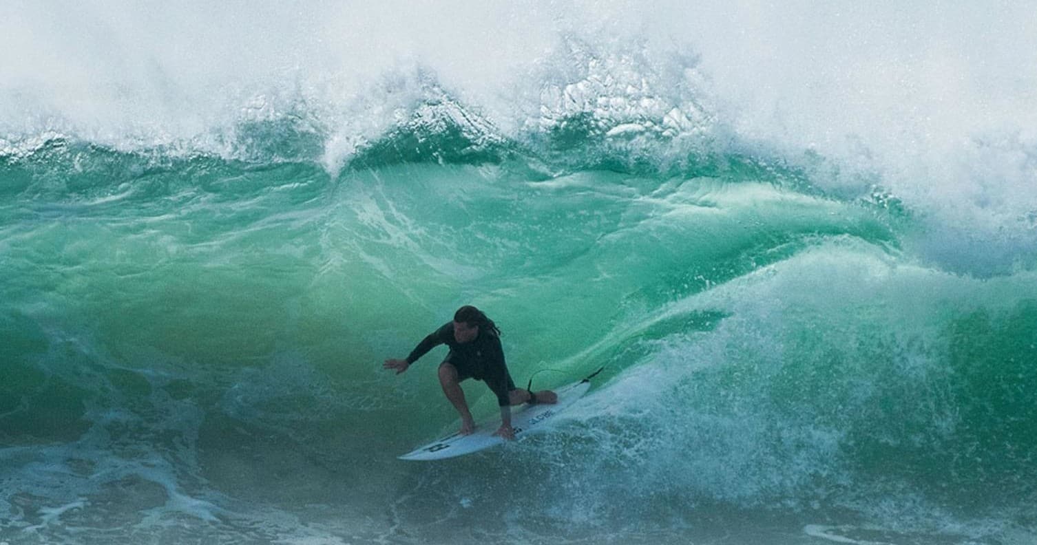 Surfer carving a large barrel wave off Mandurah coastline