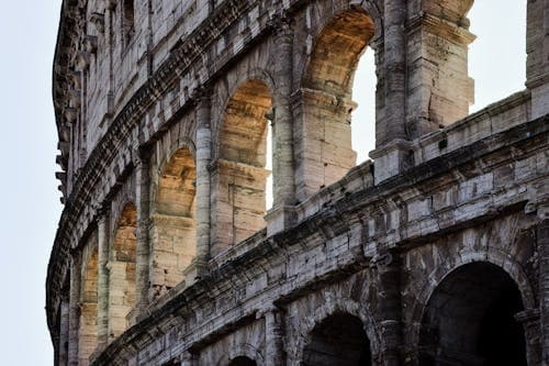 Colosseum exterior arches at golden hour, historic Rome landmark
