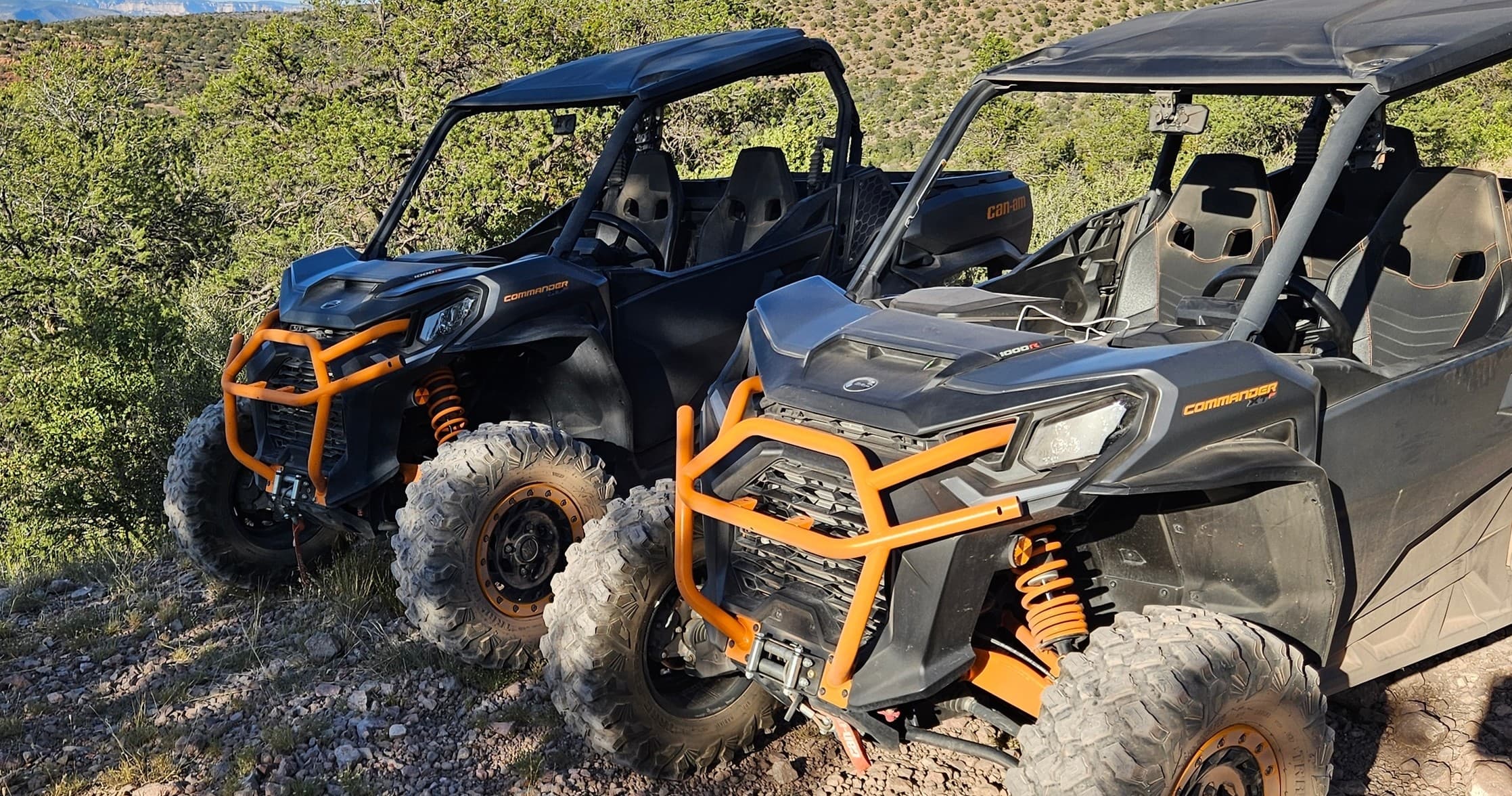 Two side-by-side UTVs parked on rocky trail showcasing off-road