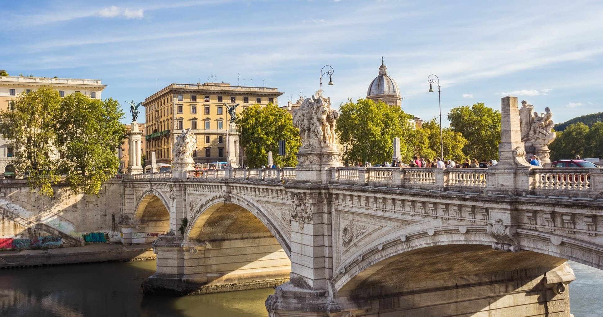Tiber River and arched bridge with Rome city skyline at dusk