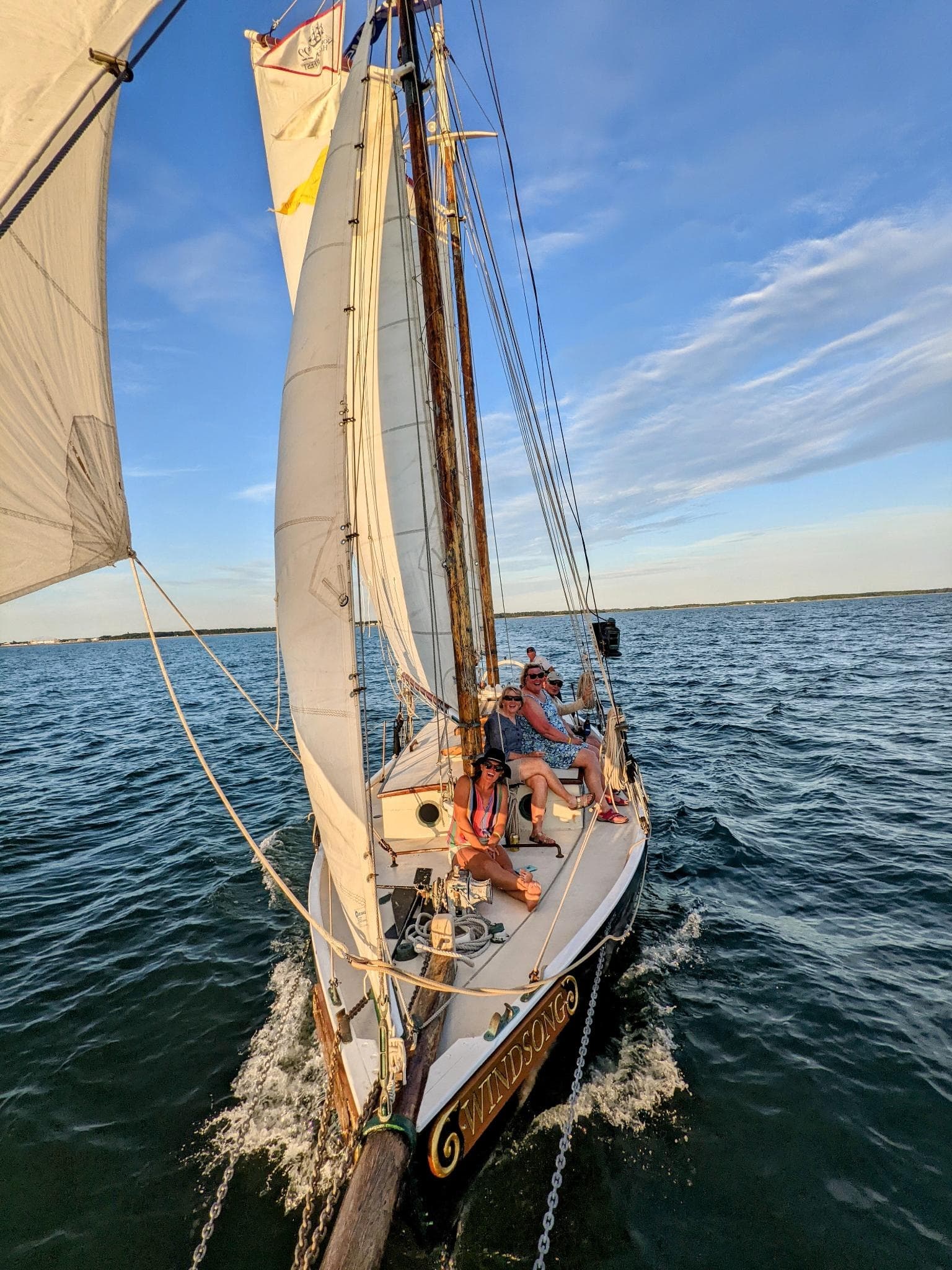 Crew aboard schooner bow navigating choppy coastal waters