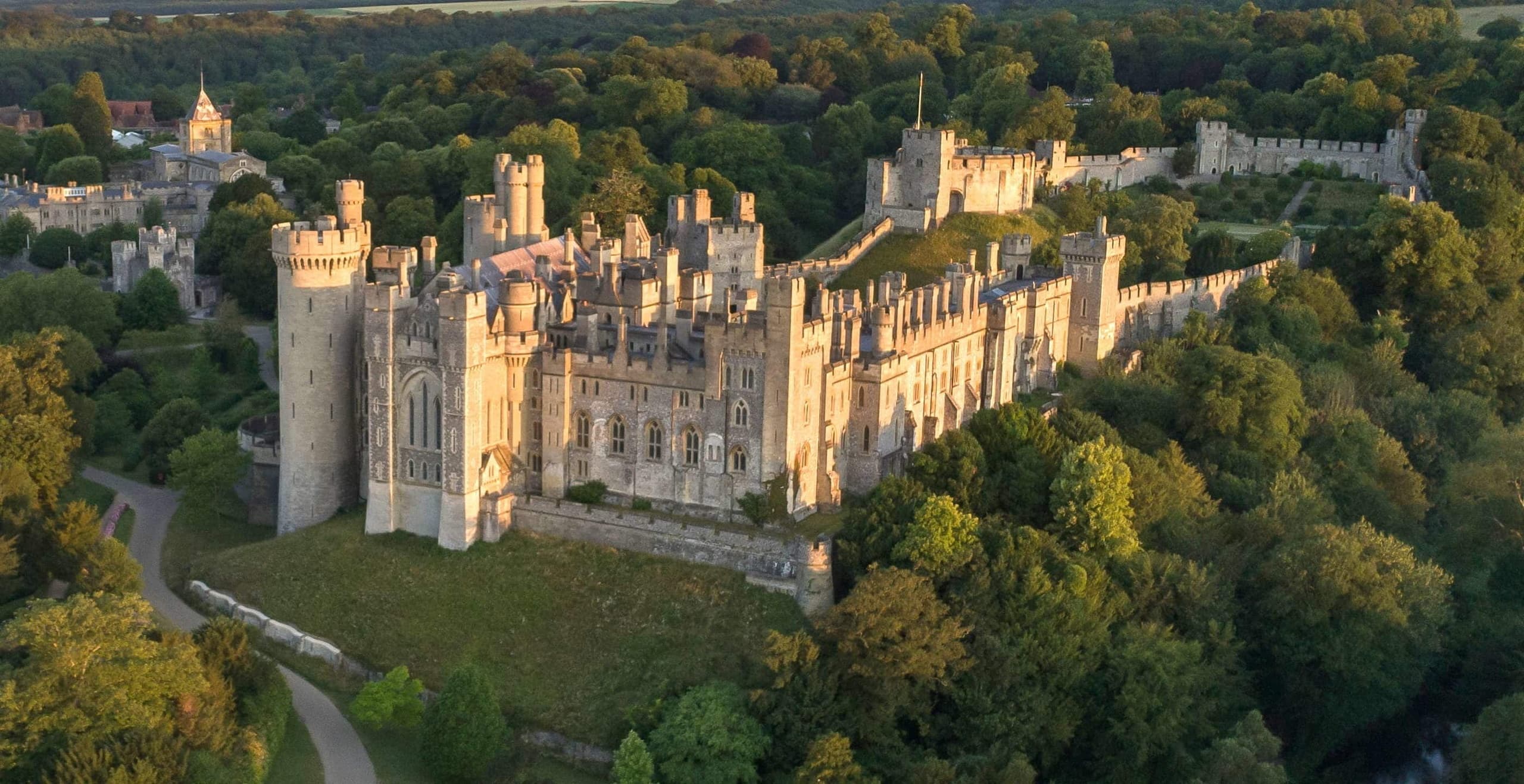Cyclists near historic castle estate on scenic aerial tour