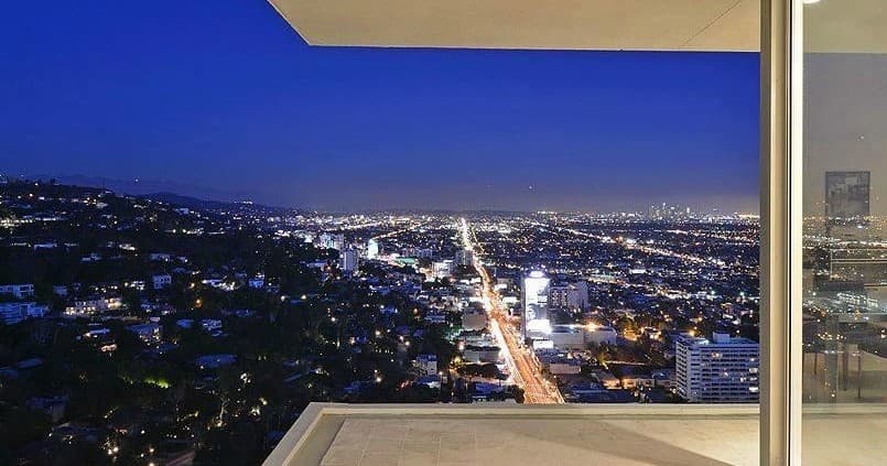 Panoramic Los Angeles skyline at night from hillside balcony