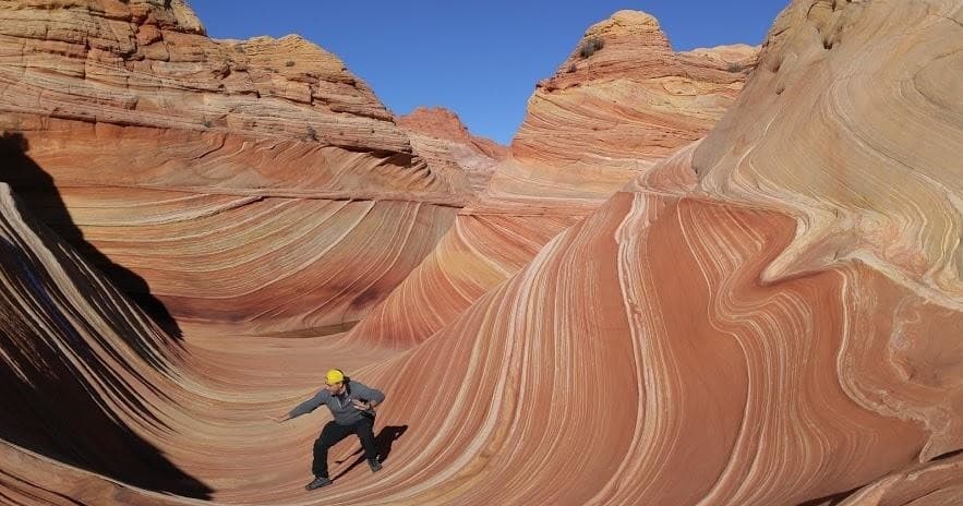 Hikers posing on rocky canyon overlook during desert trek