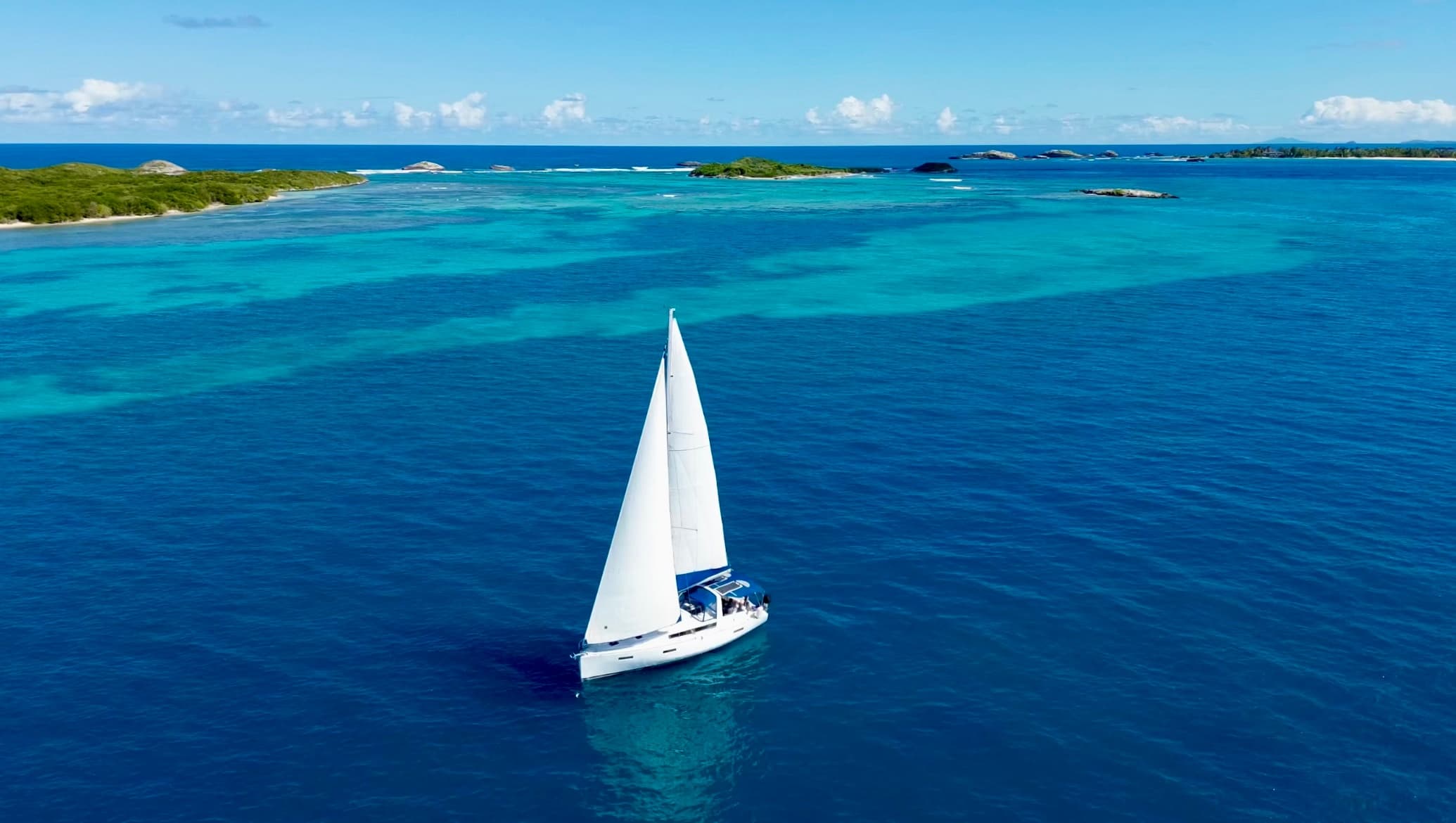 Aerial sailboat cruising deep blue Caribbean waters