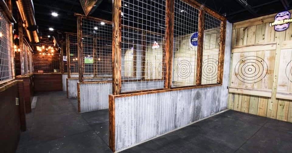 Angled indoor axe throwing lanes with rustic wooden targets