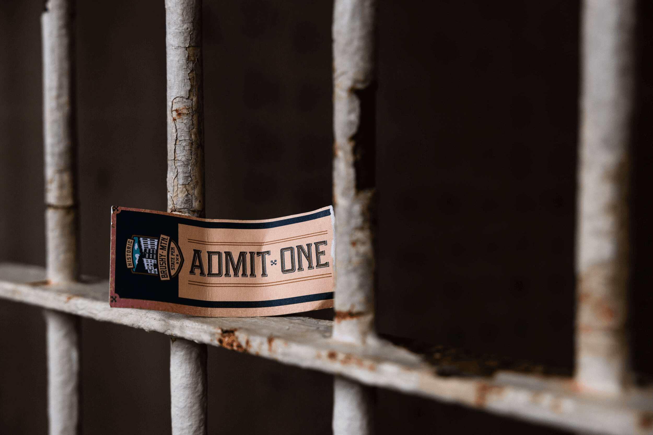 Admission ticket on rusted cell bars, prison tour experience close-up