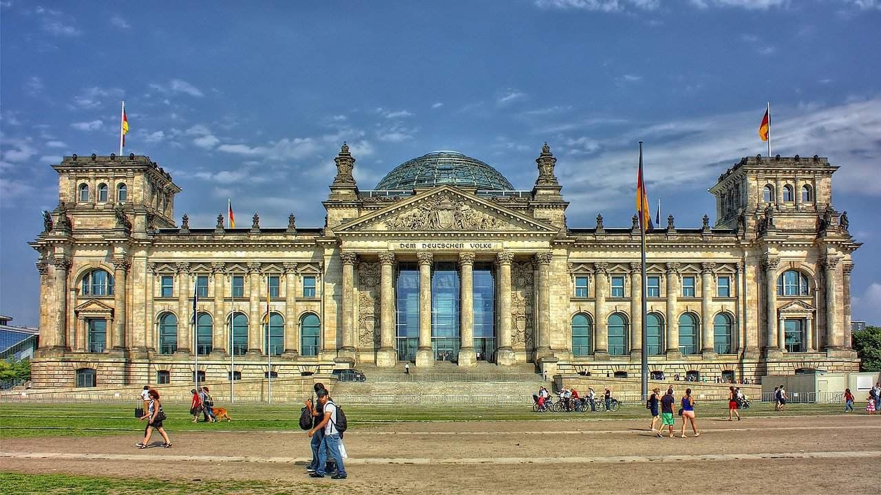 Tourists strolling in front of the Reichstag building in Berlin