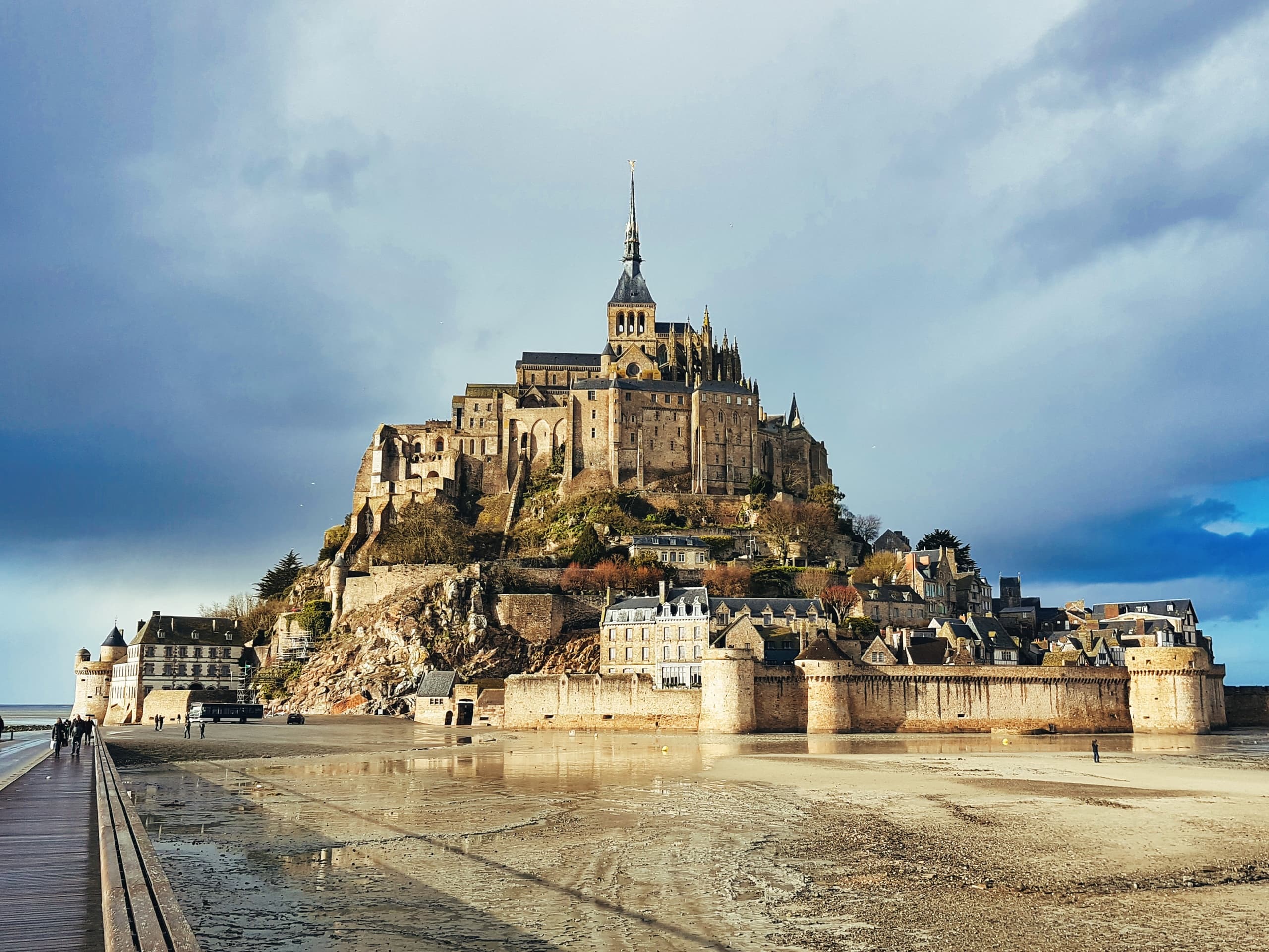 Mont Saint-Michel island abbey at low tide with dramatic sky