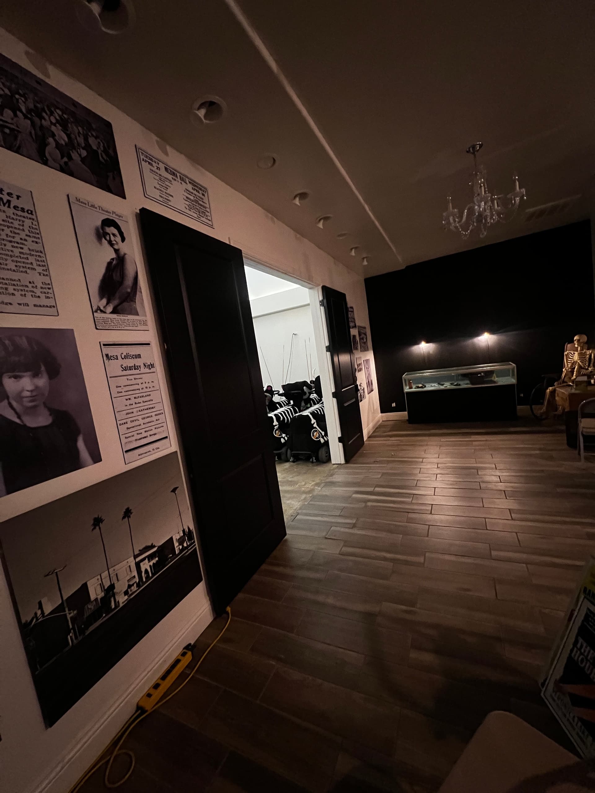 Dimly lit paranormal exhibit hallway with display cases and photos