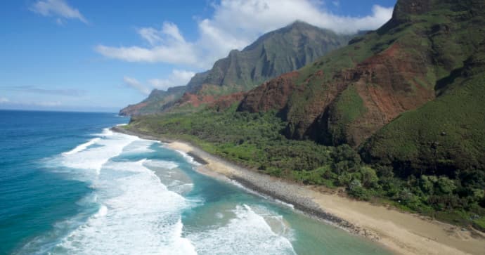 Aerial coastal view of Na Pali cliffs and surf on Kauai