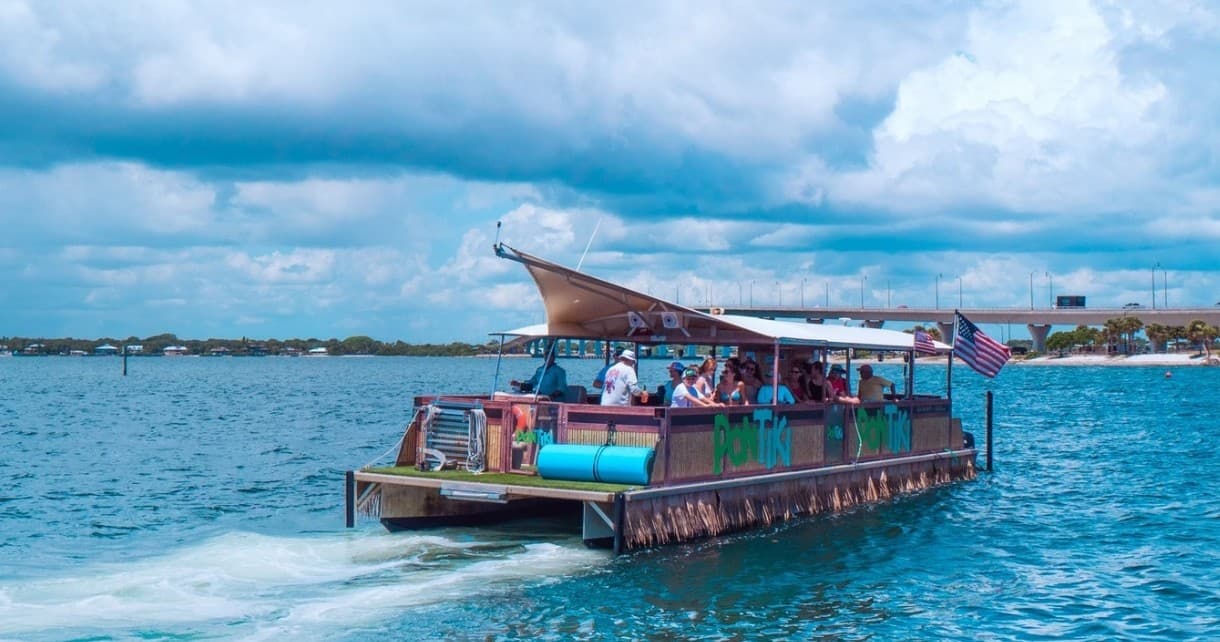 Party pontoon boat speeding on ocean under dramatic cloudy sky