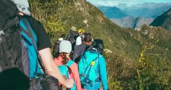 Group hiking along scenic mountain ridge on summer trek
