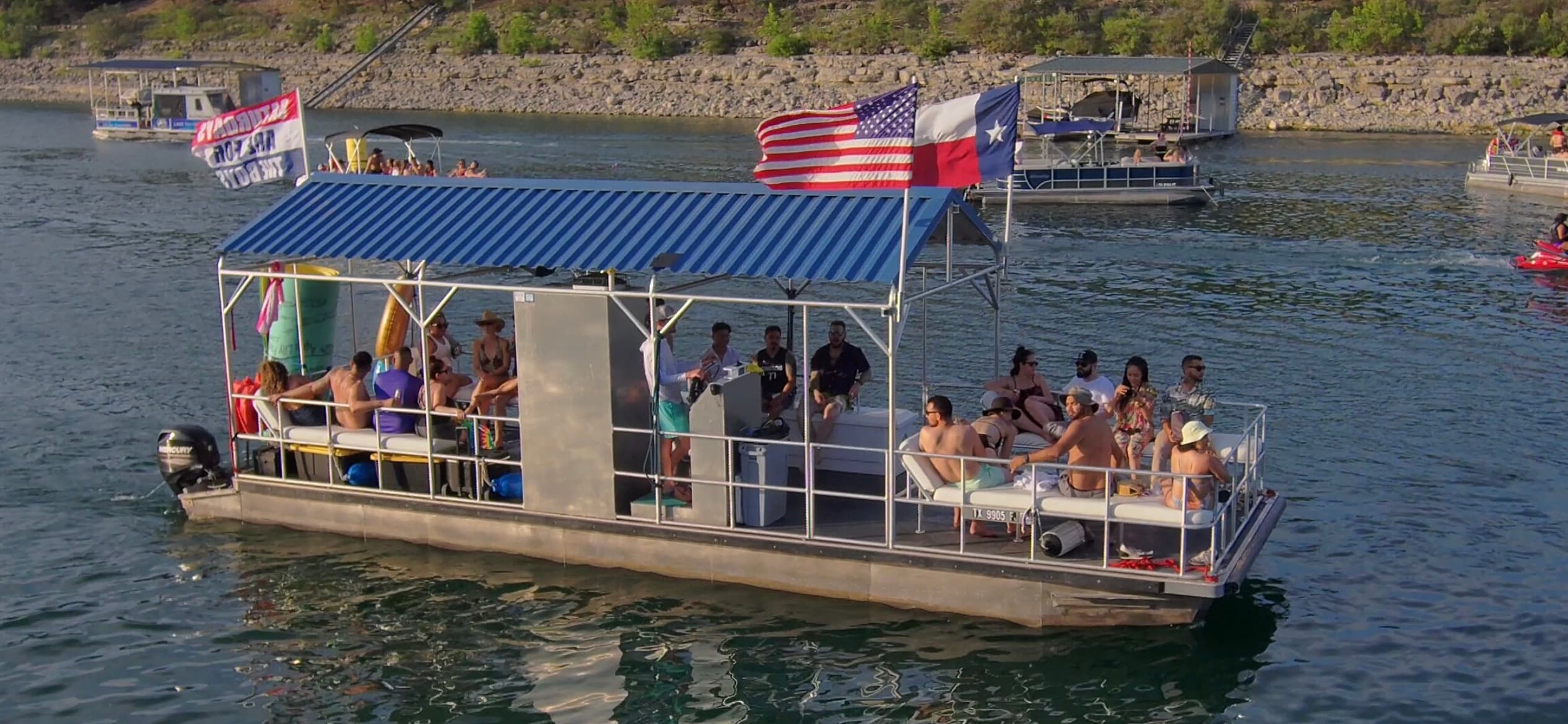Pontoon party boat with passengers on Lake Travis shoreline cruise