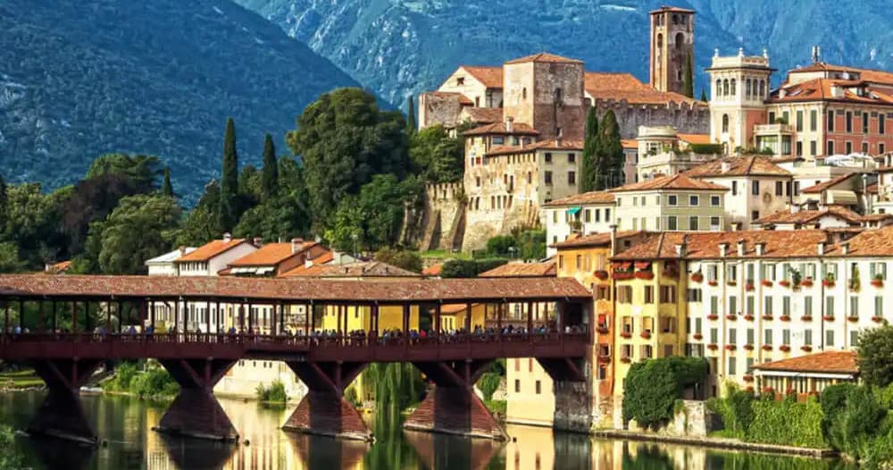 Historic riverside town with arched bridge and hillside village
