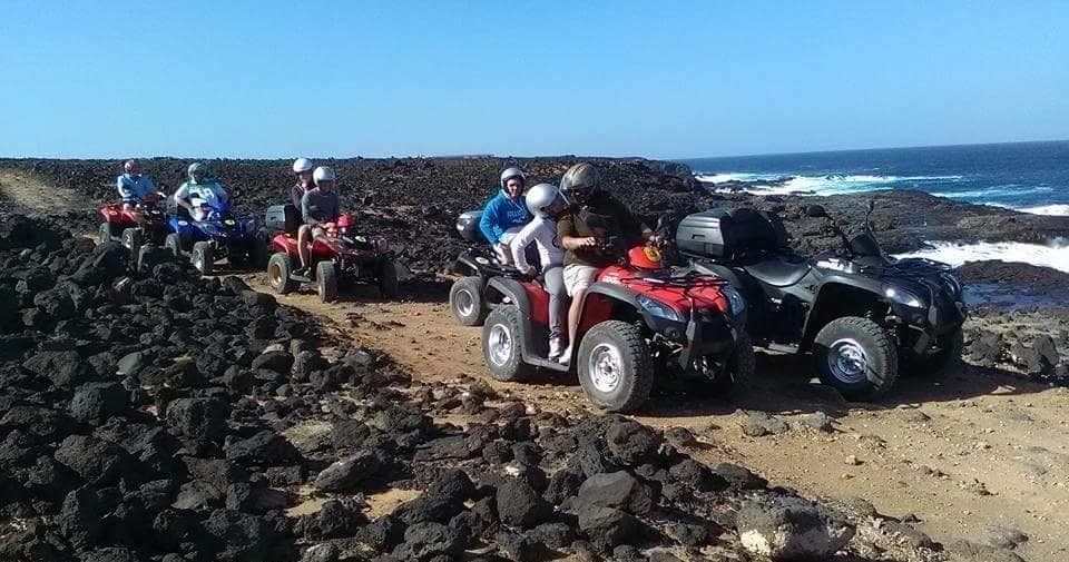 ATV riders exploring rocky Lanzarote coastline on tour