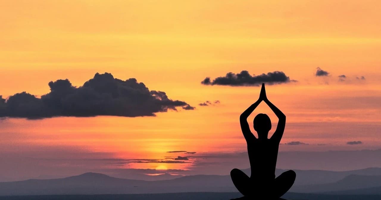 Sunset yoga silhouette on beach overlooking the ocean