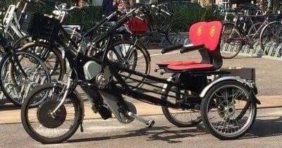 Adaptive three-wheeled bike parked among city bicycles