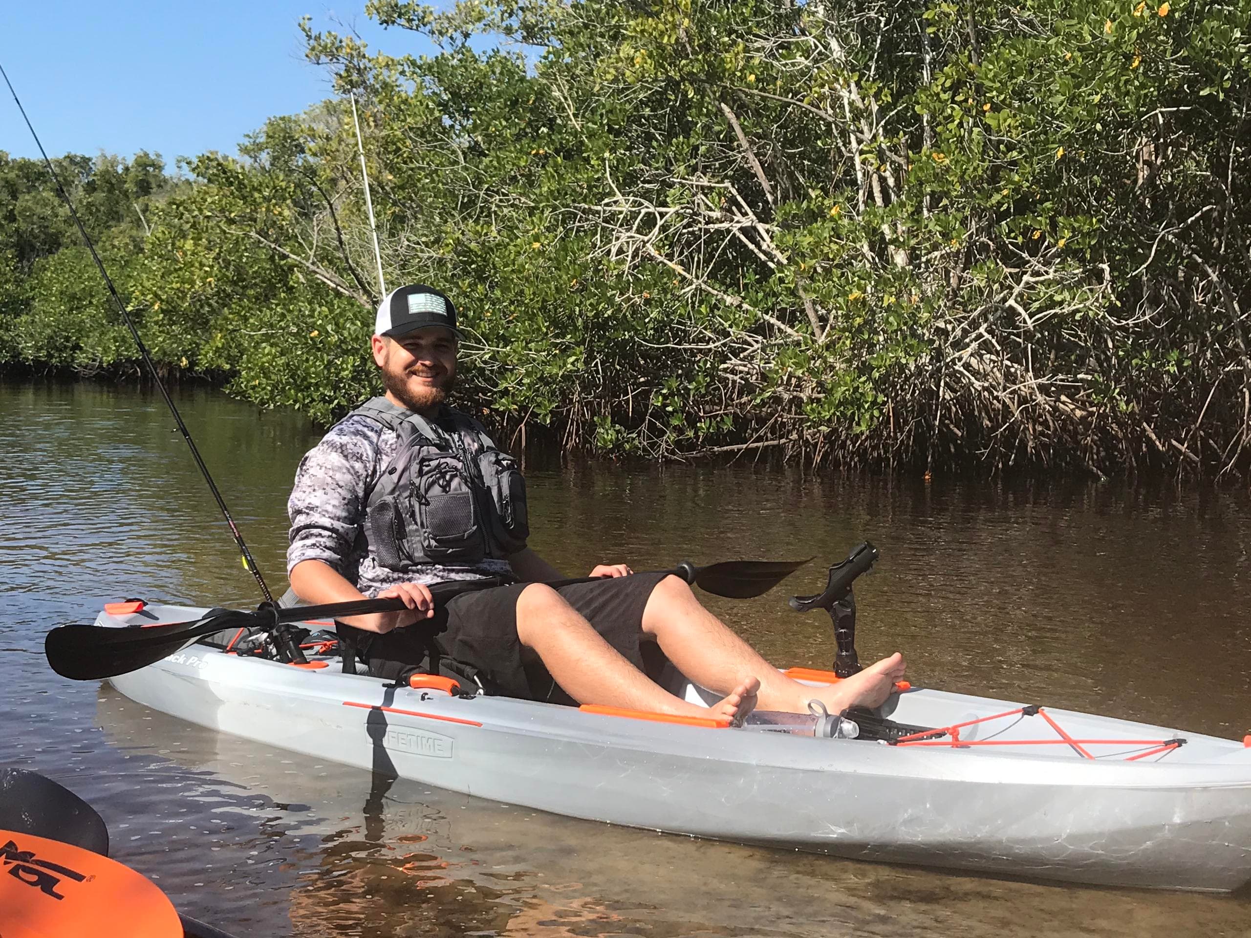 Solo angler kayak in shallow mangrove waters, recreational fishing