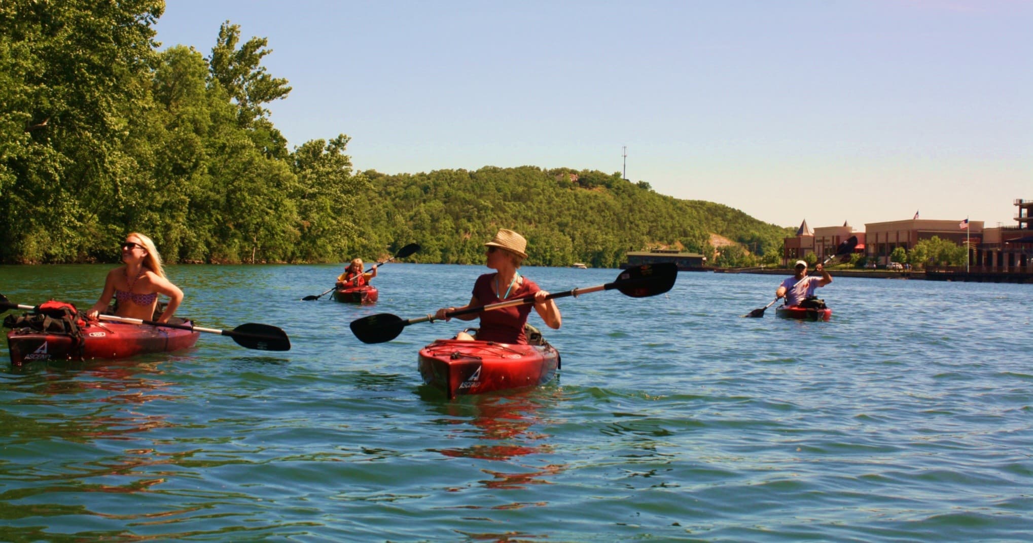 Kayakers paddling on scenic river with forested shoreline