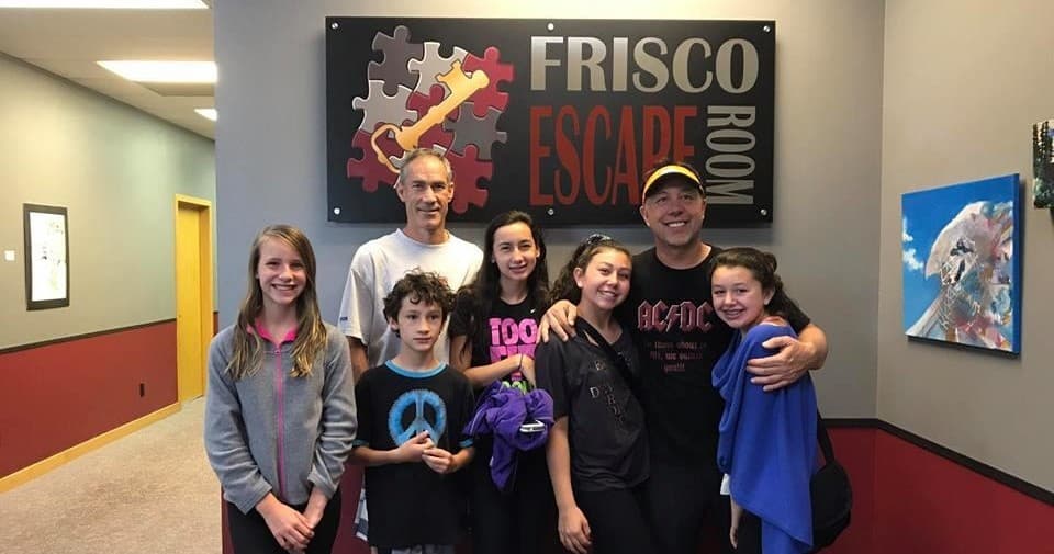Group celebrating at Frisco Escape Room lobby after escape