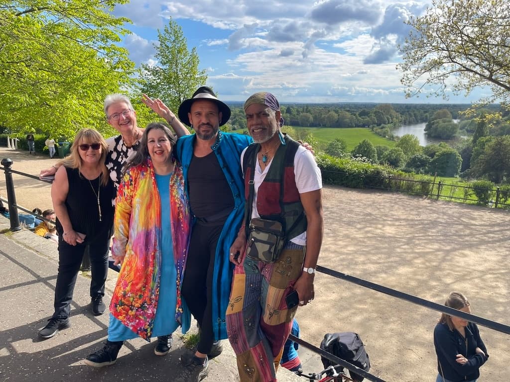 Group posing on hill with scenic park and river vista