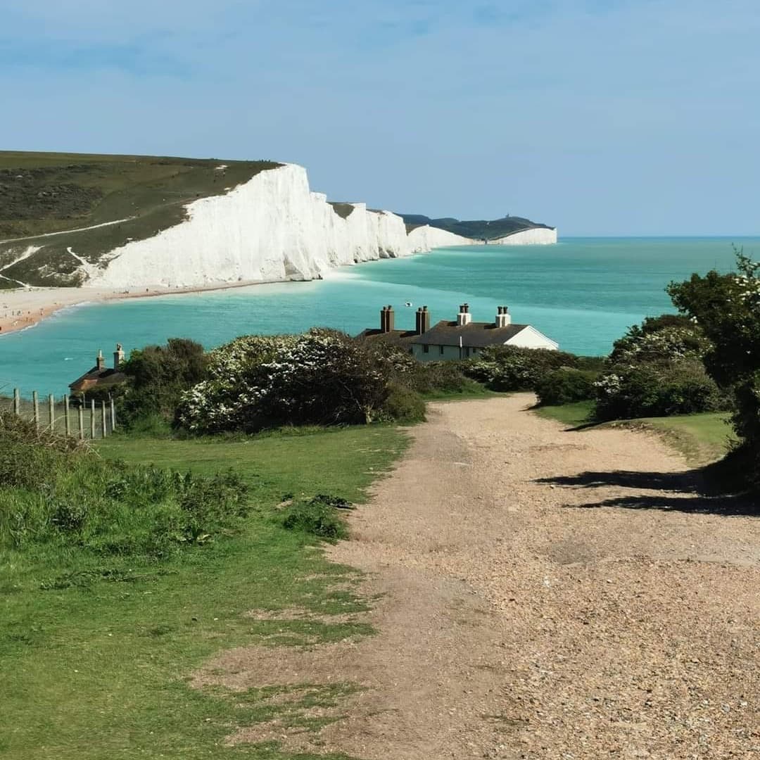 Coastal walking path toward white cliffs, scenic seaside trail